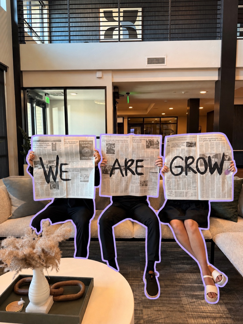 The Grow Studio founders holding up newspapers reading "We are Grow"